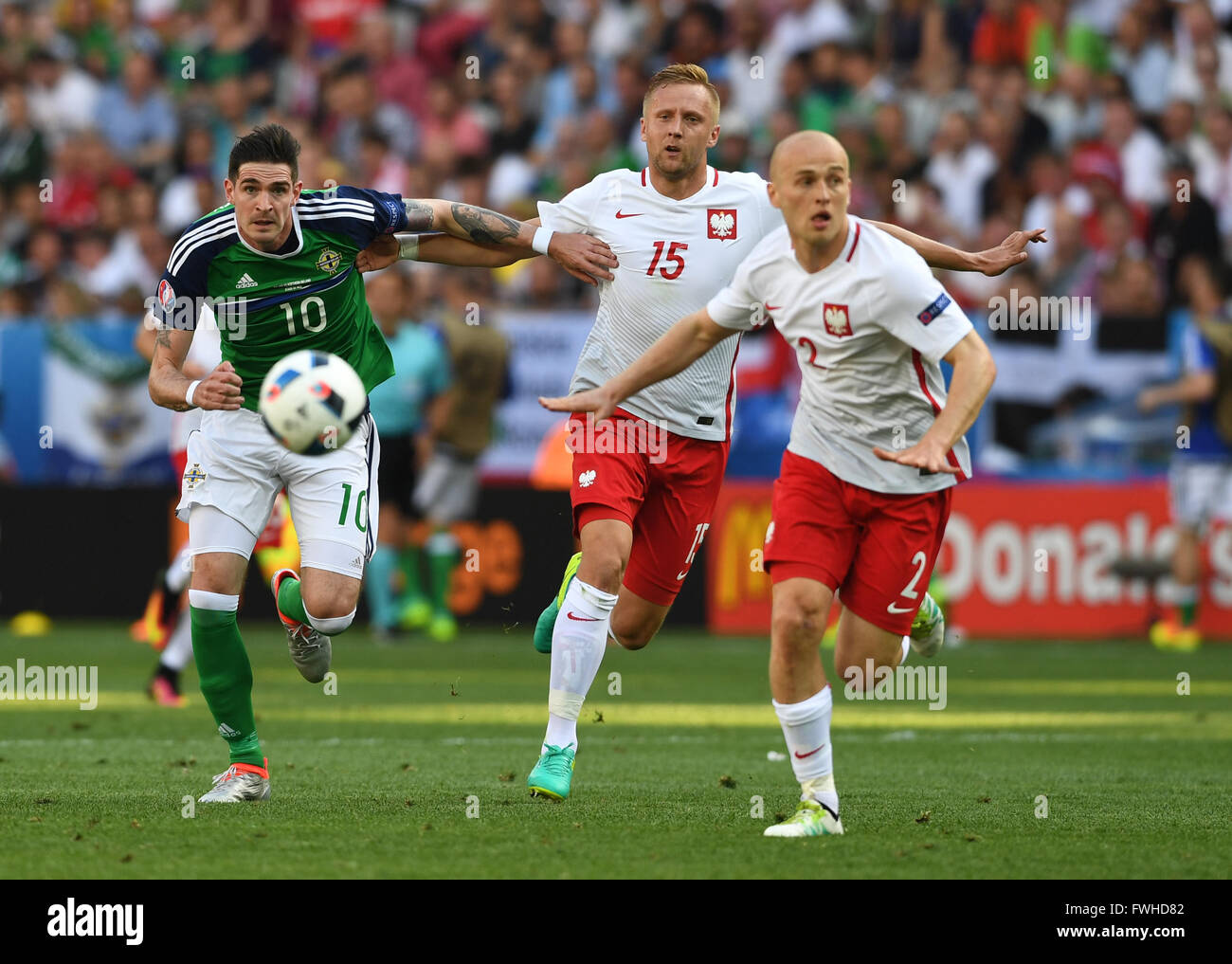 Michal Pazdan (R-L), Kamil Glik di Polonia e Kyle Lafferty dell Irlanda del Nord sfida per la sfera durante UEFA EURO 2016 gruppo C partita di calcio tra la Polonia e Irlanda del Nord di Nizza, Francia, 12 giugno 2016. Foto: Federico Gambarini/dpa Foto Stock