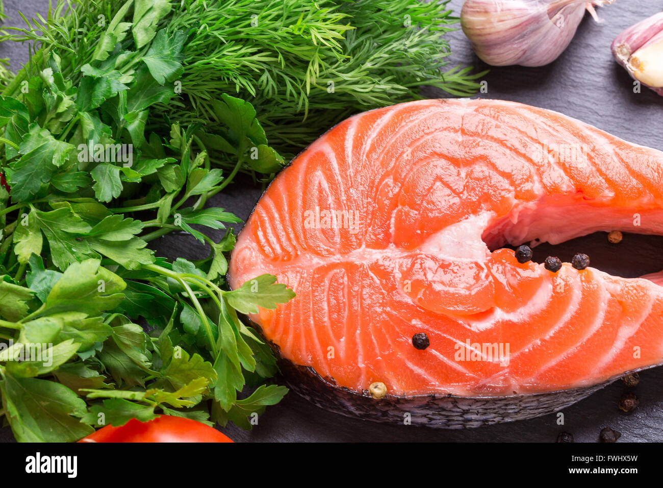 Pesce rosso bistecca con verde su una tavola di ardesia. Foto Stock