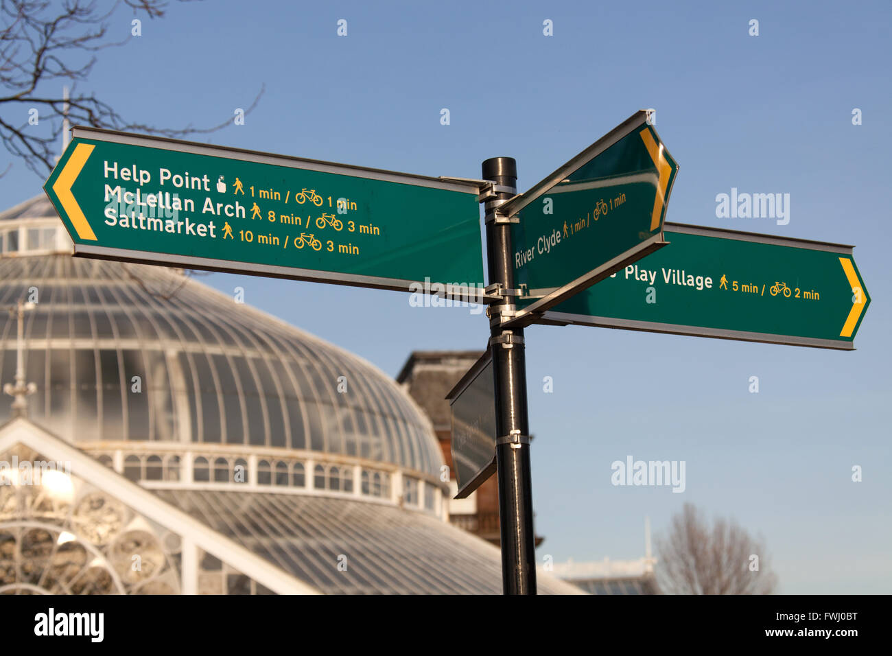 Città di Glasgow, Scozia. Visitatore segno di direzione a Glasgow Green con il Palazzo del Popolo e il giardino di inverno in background. Foto Stock