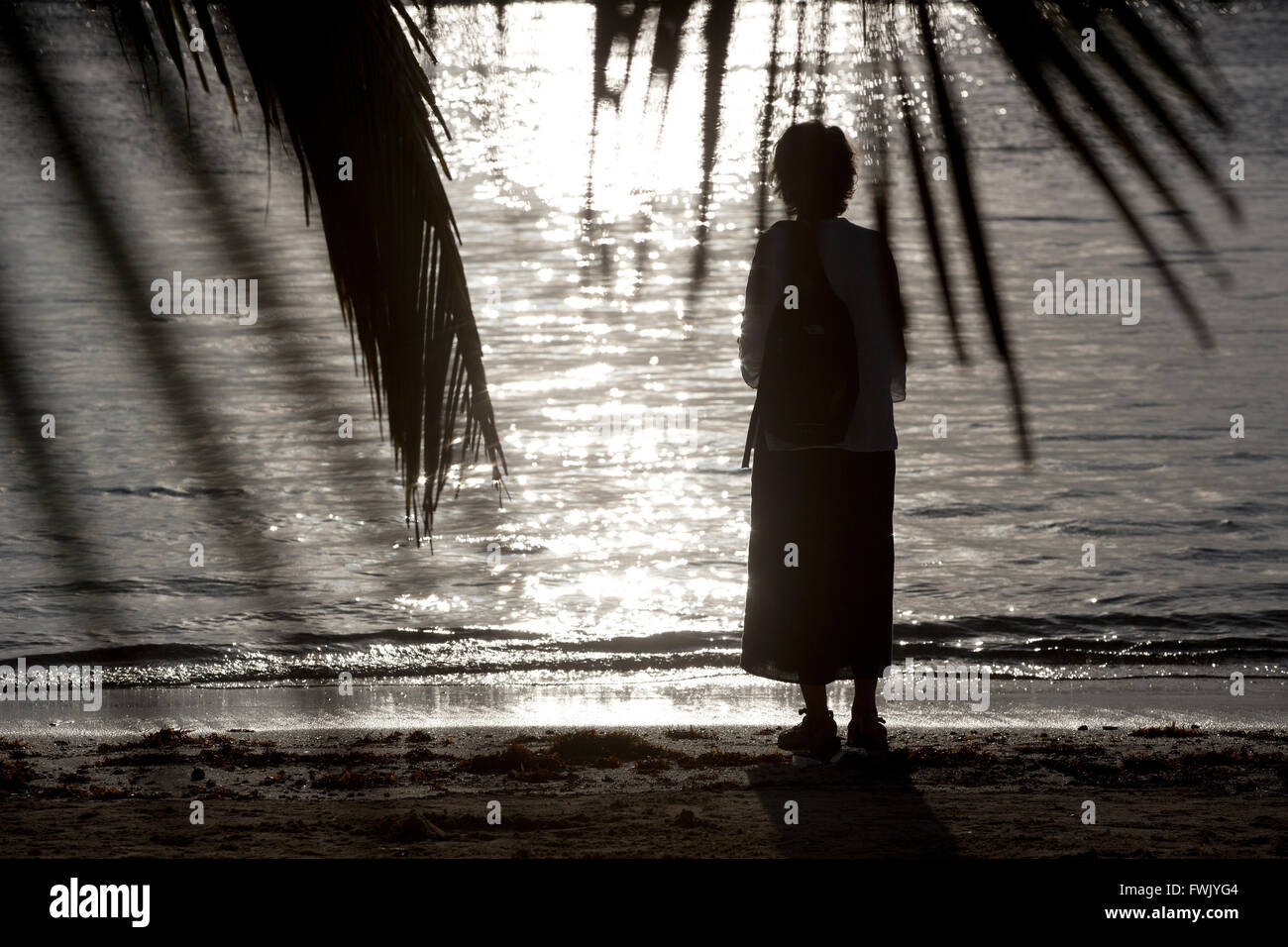 Donna sulla spiaggia al tramonto, Mahahual, Messico Foto Stock