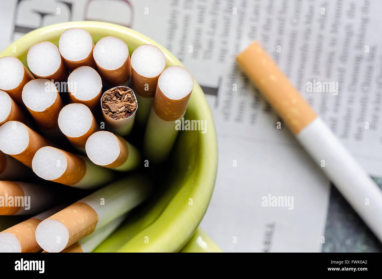 Vista ravvicinata di tabacco di sigaretta nella tazza verde. Foto Stock