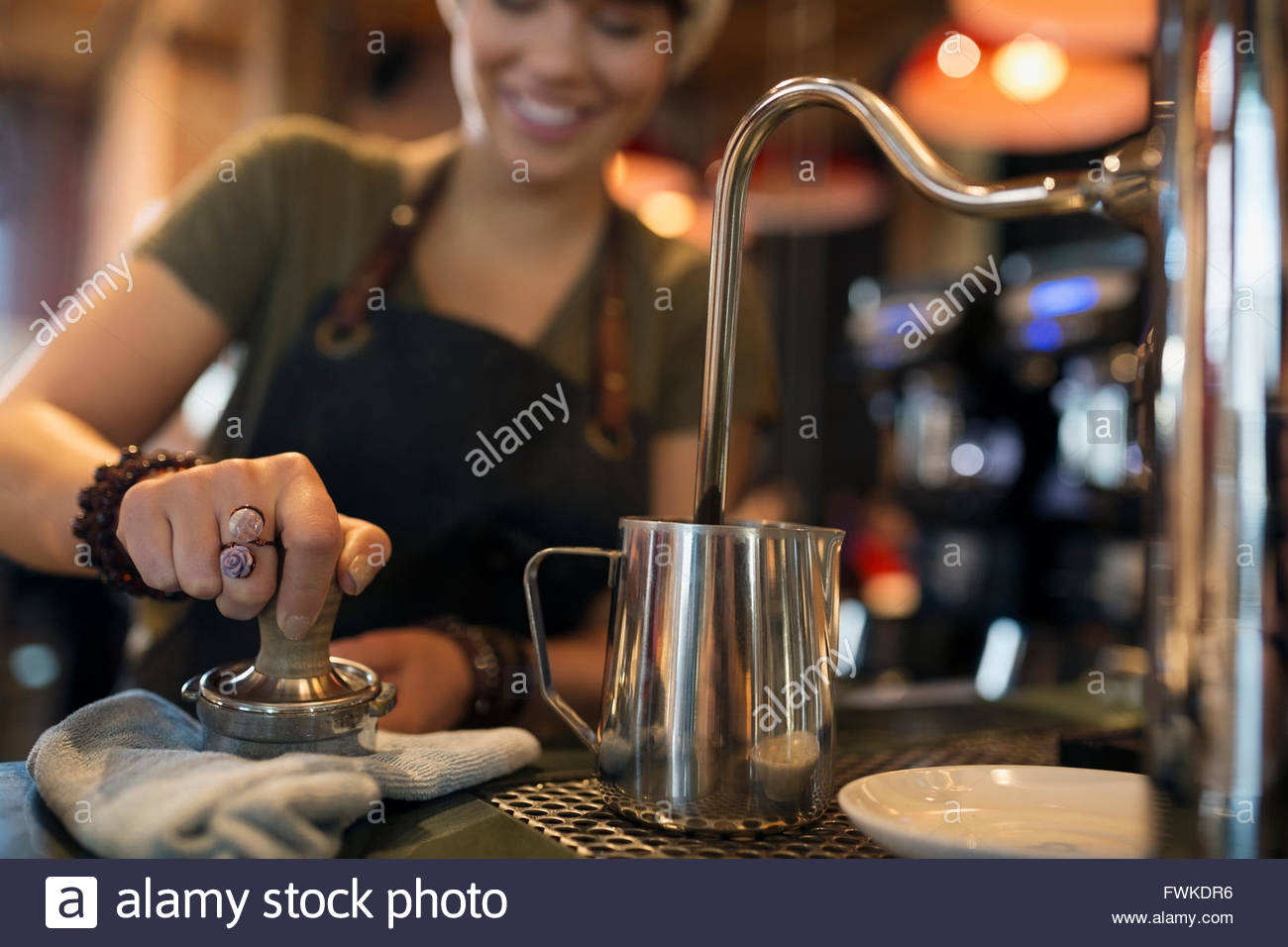 Barista espresso di pressatura con dispositivo antimanomissione in coffee shop Foto Stock