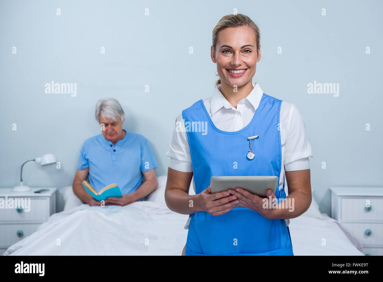 Infermiera sorridente azienda digitale compressa all'ospedale Foto Stock