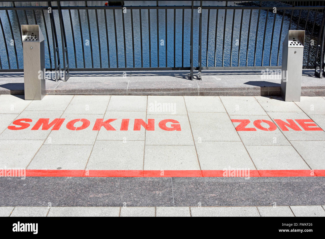 Contrassegni sul marciapiede designata zona fumatori in spazio aperto tra i blocchi degli uffici di Canary Wharf London Docklands Isle of Dogs Tower Hamlets England Regno Unito Foto Stock