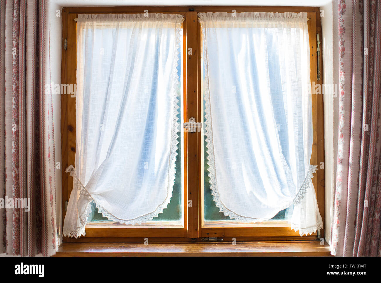 Vecchia finestra in legno con tende bianche in una casa tradizionale nelle  Alpi Foto stock - Alamy