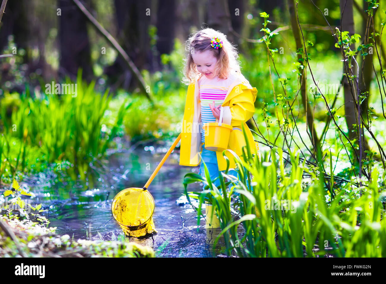 Bambino che gioca all'esterno. Preschooler kid la cattura del pesce con asta rossa. Bambina con attività di pesca in una foresta fiume in estate Foto Stock