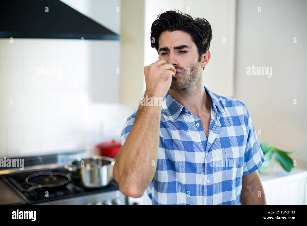 Uomo che dà un bacio battenti in cucina Foto Stock