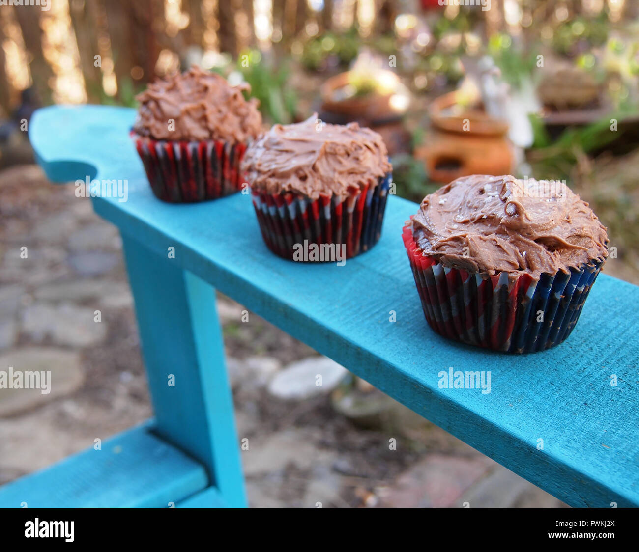 Tre in casa tortini di cioccolato in 4 di Luglio di involucri sul braccio di una sedia adirondack nel giardino. Foto Stock