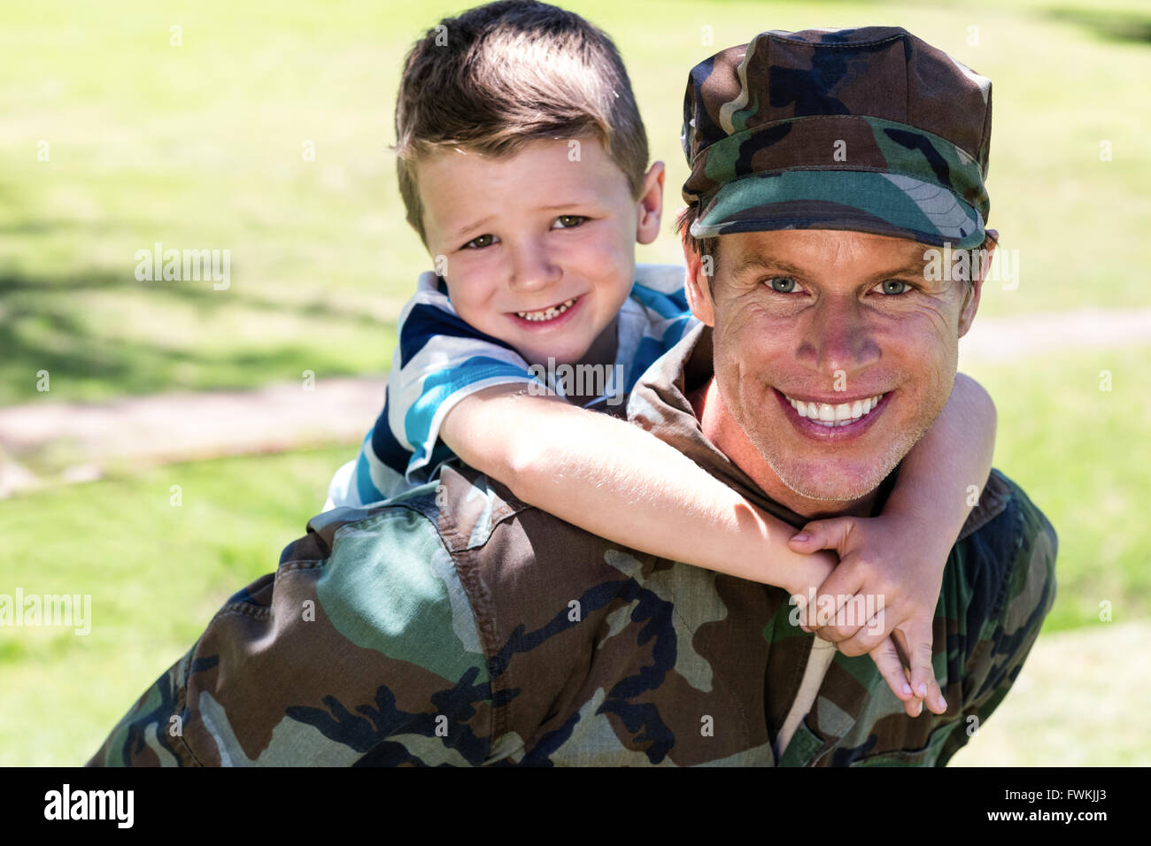 Felice soldato dando sovrapponibile al suo figlio Foto Stock