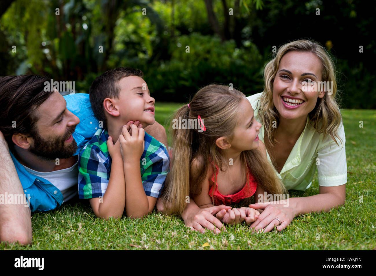 Padre e figli guardando la madre in cantiere Foto Stock