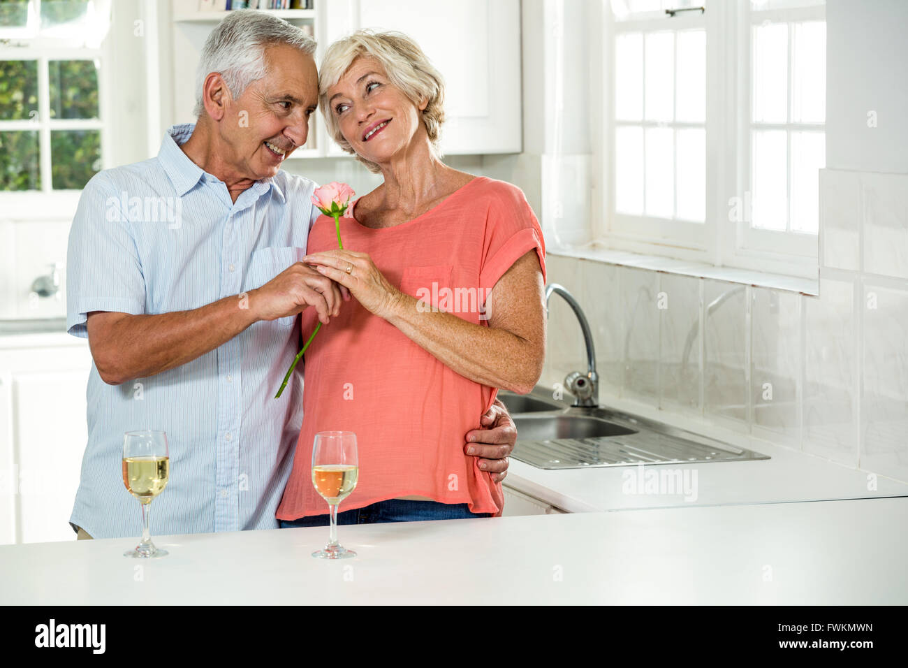 Sorridente coppia senior con rose Foto Stock