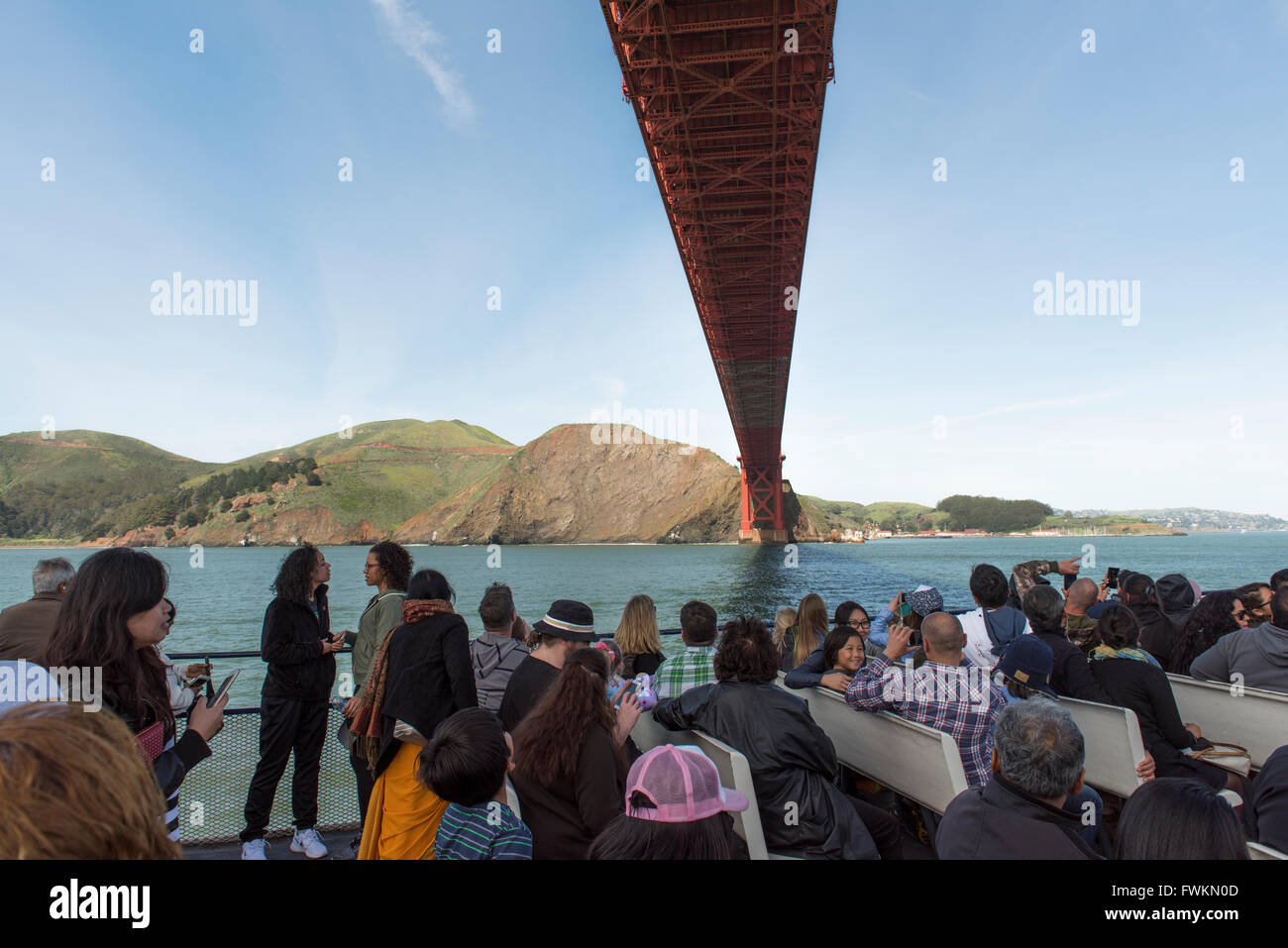 I turisti su una barca direttamente sotto il Ponte Golden Gate, nella Baia di San Francisco, California, Stati Uniti d'America Foto Stock