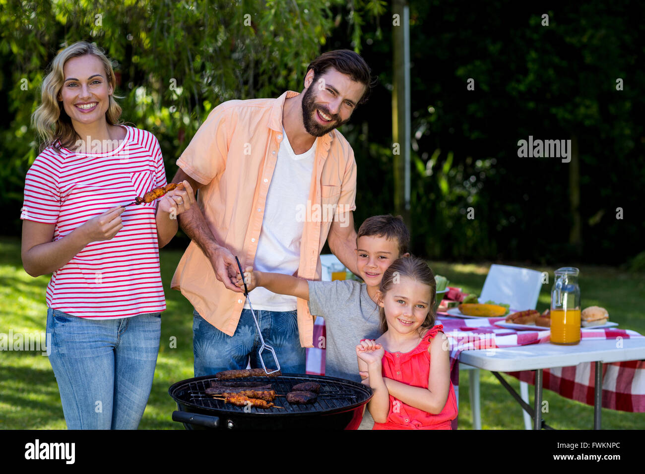 Famiglia di cottura degli alimenti su barbecue grill al cantiere Foto Stock