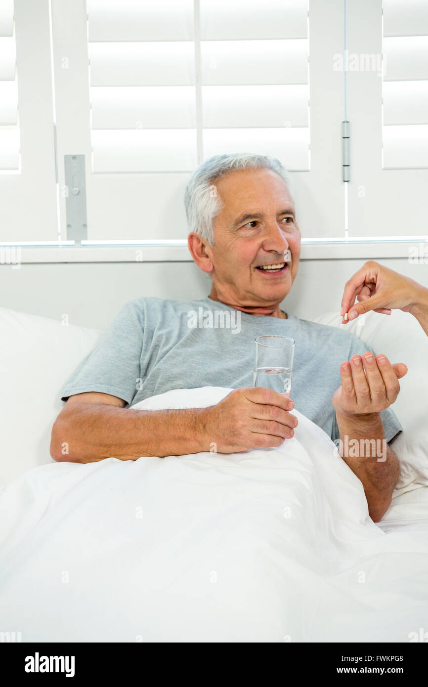 Immagine ritagliata del medico di medicina dando al vecchio uomo Foto Stock