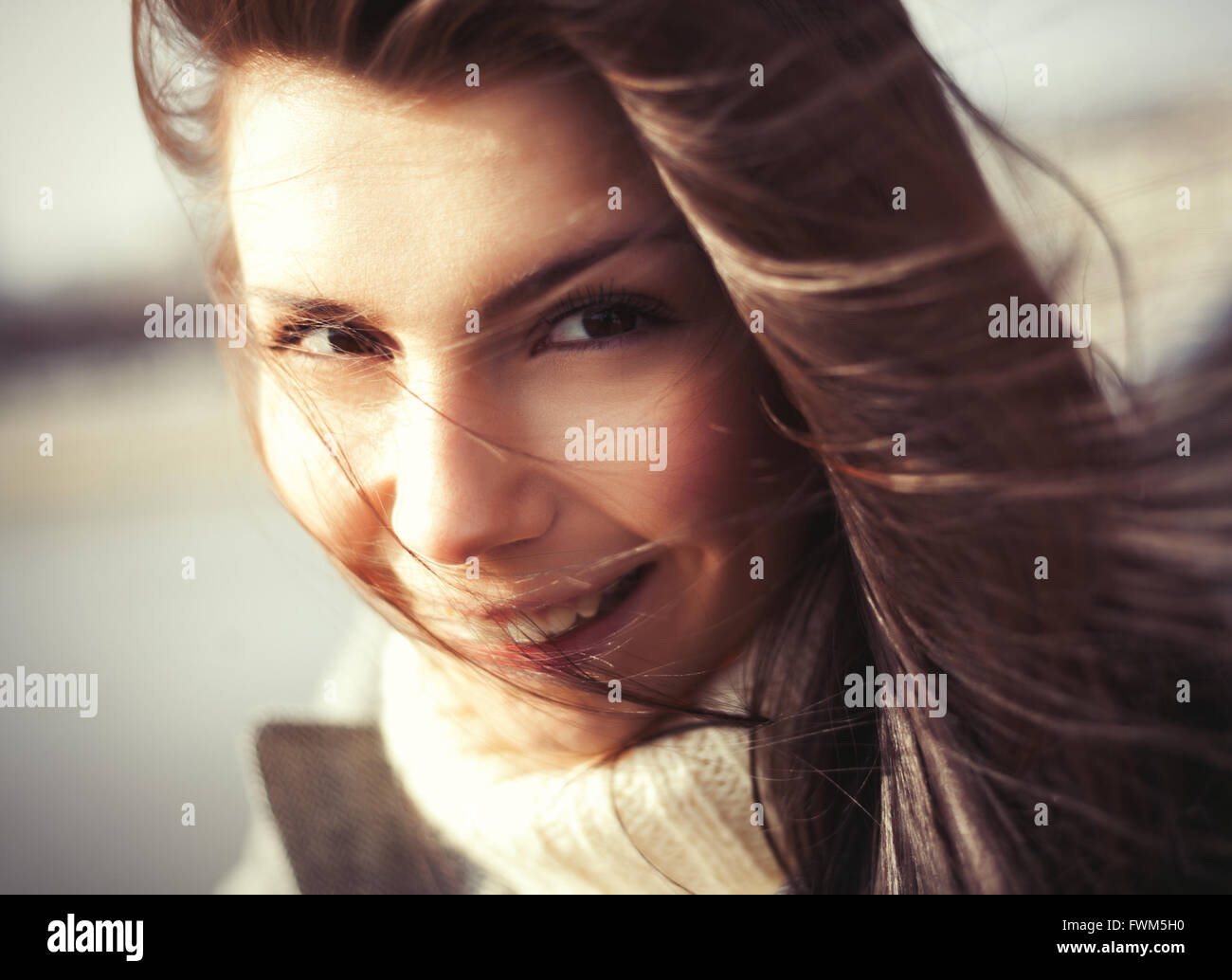 Windy ritratto di attraente giovane donna con un allegro sorriso toothy. Il modello mostra friendly l'espressione del viso e i suoi capelli non è solo bello da vedere Foto Stock