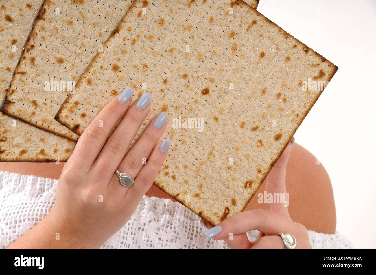 Matzo Pasqua , alla donna che indossa abito bianco mani , con belle unghie Foto Stock
