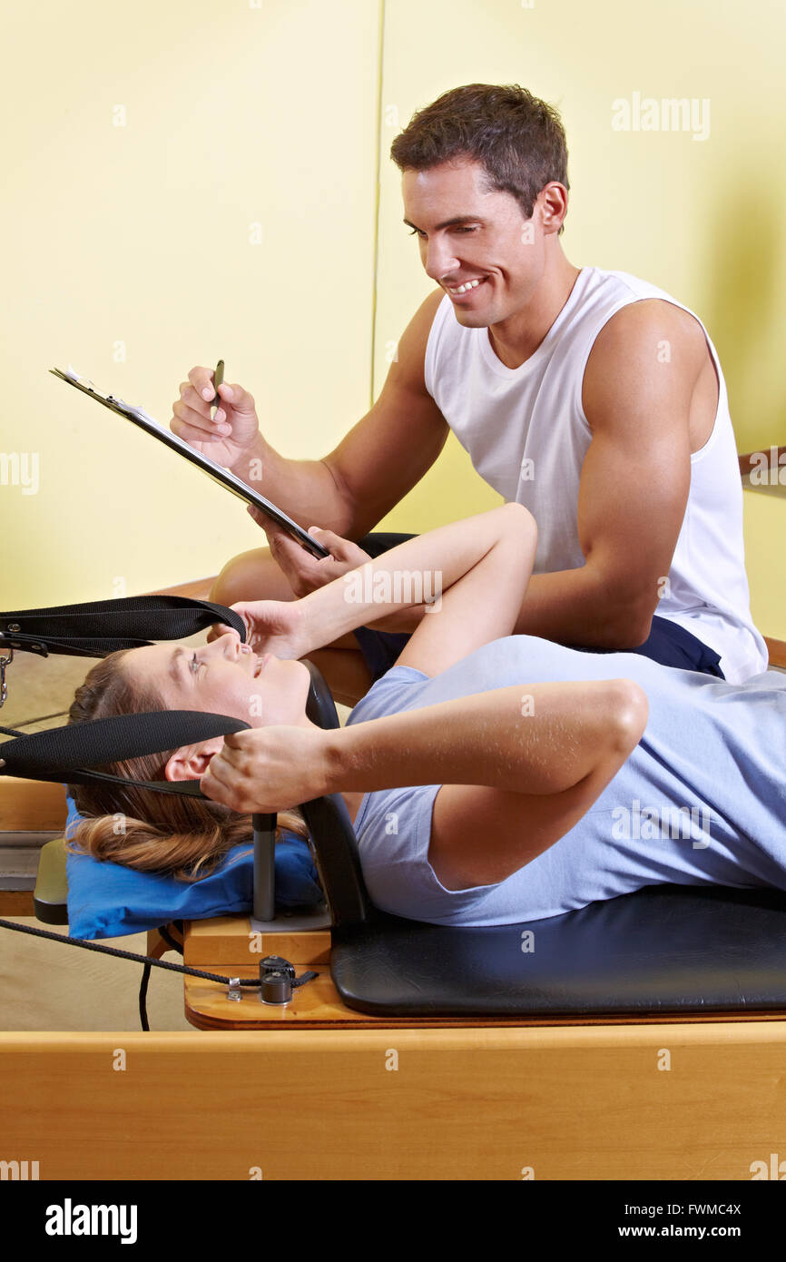 La donna e il maschio formatore di parlare nel centro fitness durante l'esercizio Foto Stock