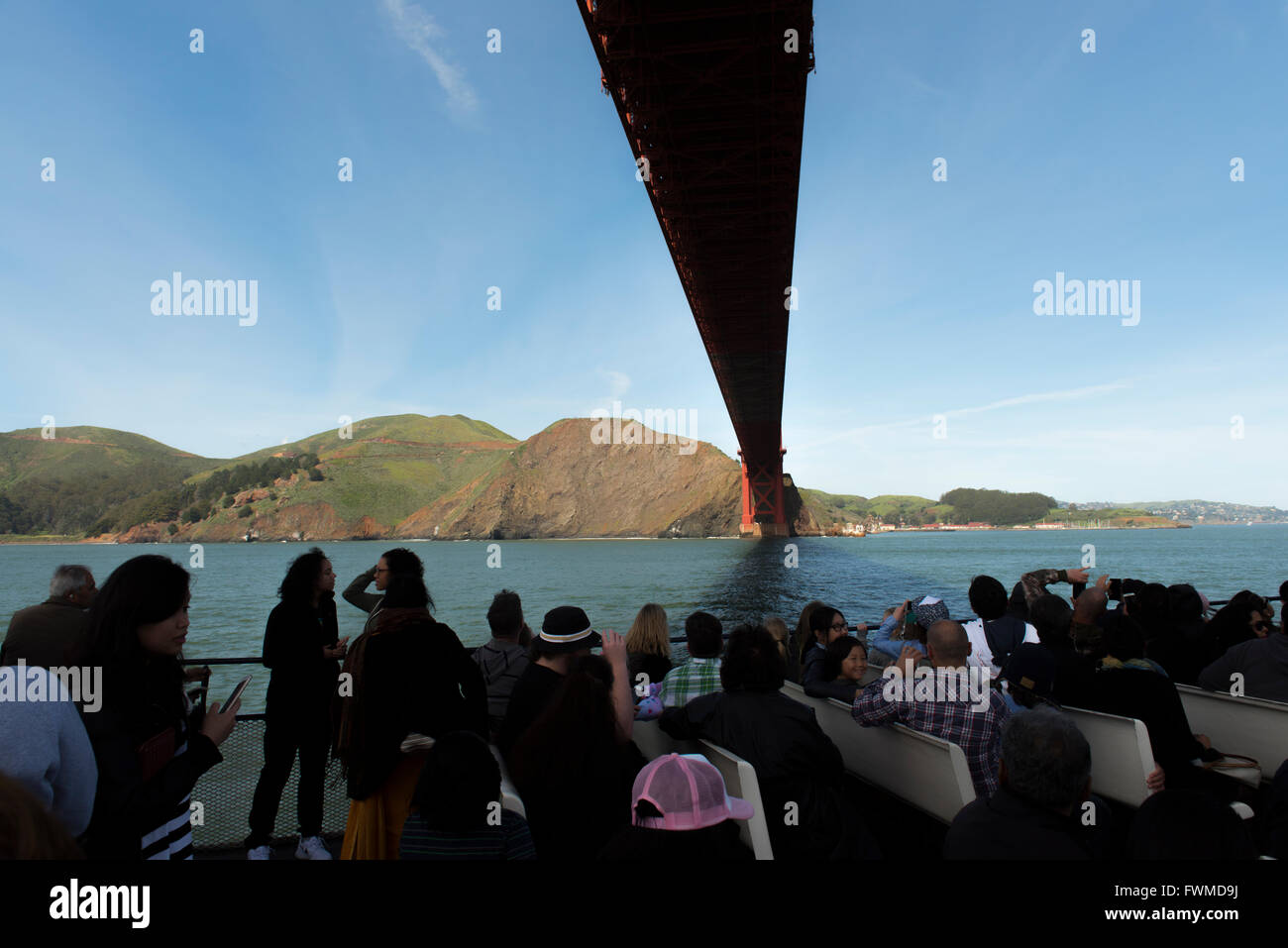 I passeggeri di un giro turistico in barca direttamente sotto il Golden Gate Bridge nella Baia di San Francisco, California, Stati Uniti d'America Foto Stock
