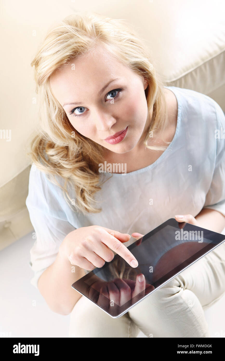 La figura di una giovane e bella bionda con una tavoletta digitale, la donna tocca lo schermo, Donna con tablet touch . Foto Stock