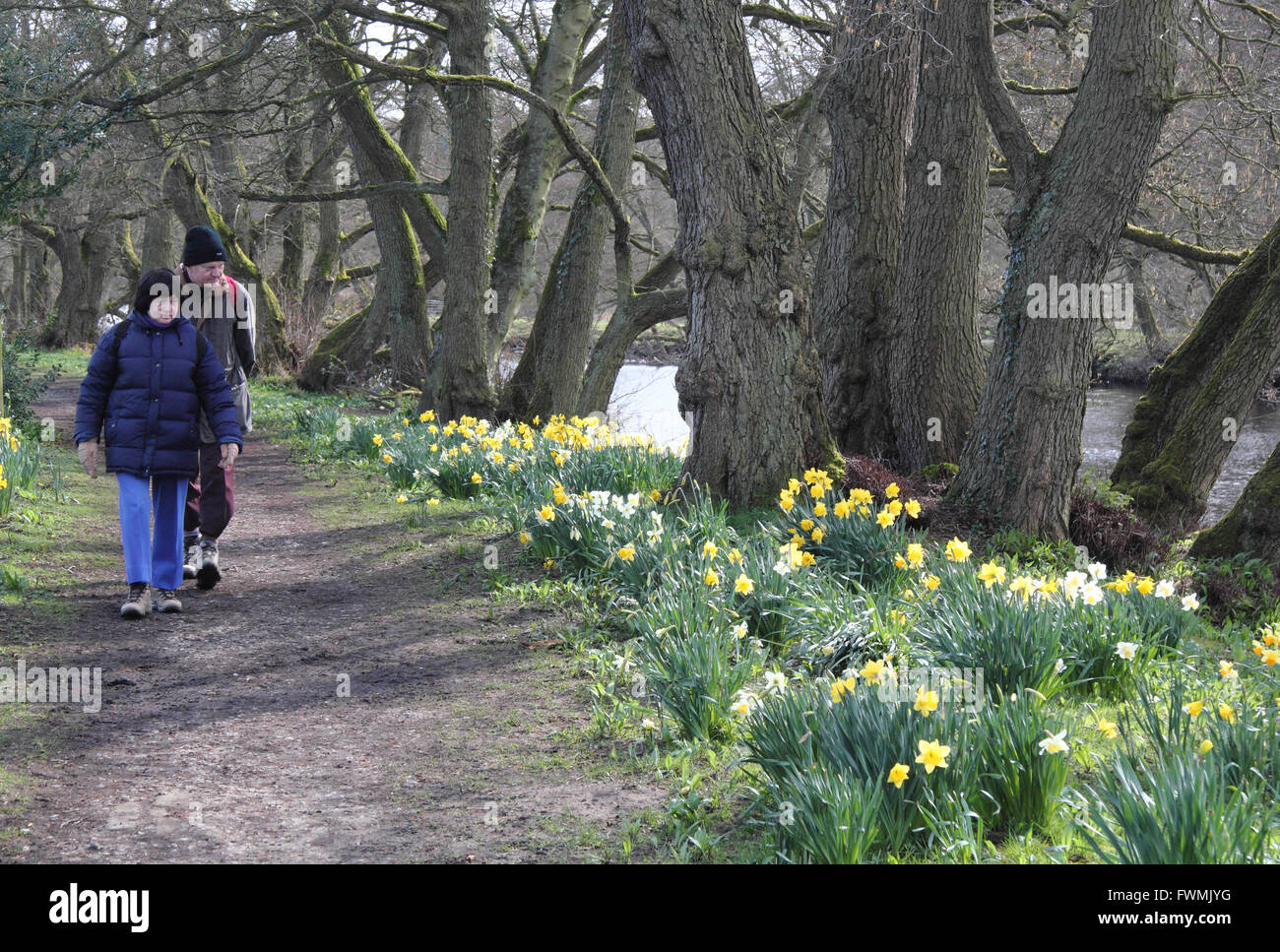 Un uomo e una donna sul sentiero lungo il Fiume Derwent al villaggio Froggatt, Peak District, Derbyshire in primavera, in Inghilterra, Regno Unito Foto Stock