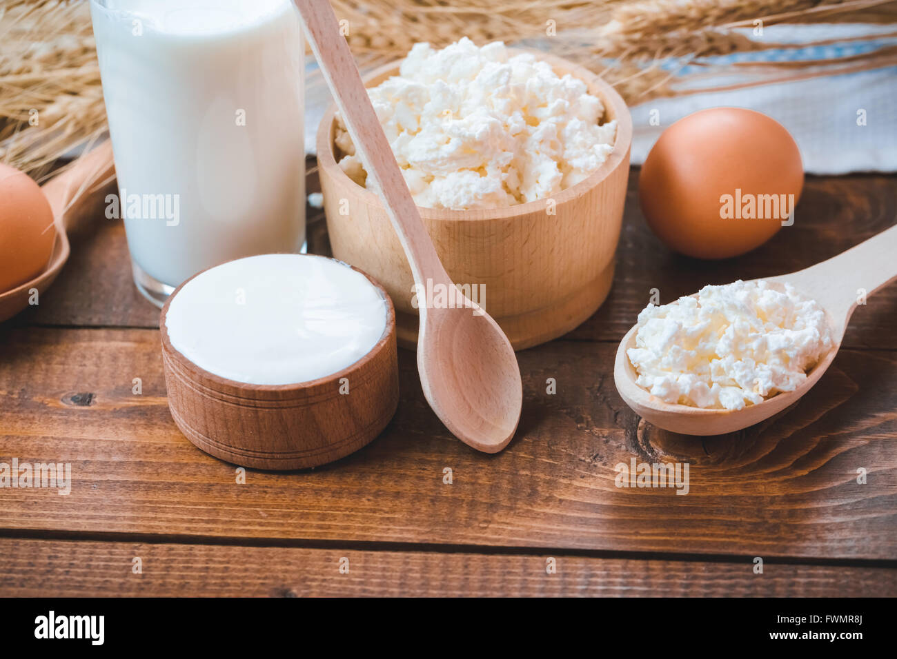Naturale prodotti fatti in casa: latte, formaggio, panna acida e uova sul vecchio sfondo di legno con spighe di grano. con lo spazio per il tuo te Foto Stock