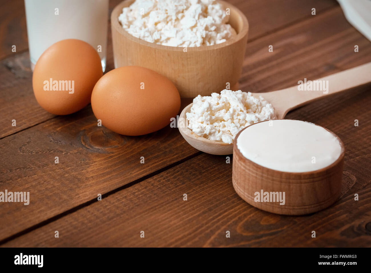 Naturale prodotti fatti in casa: latte, formaggio, panna acida e uova sul vecchio sfondo di legno con spazio libero per il testo Foto Stock