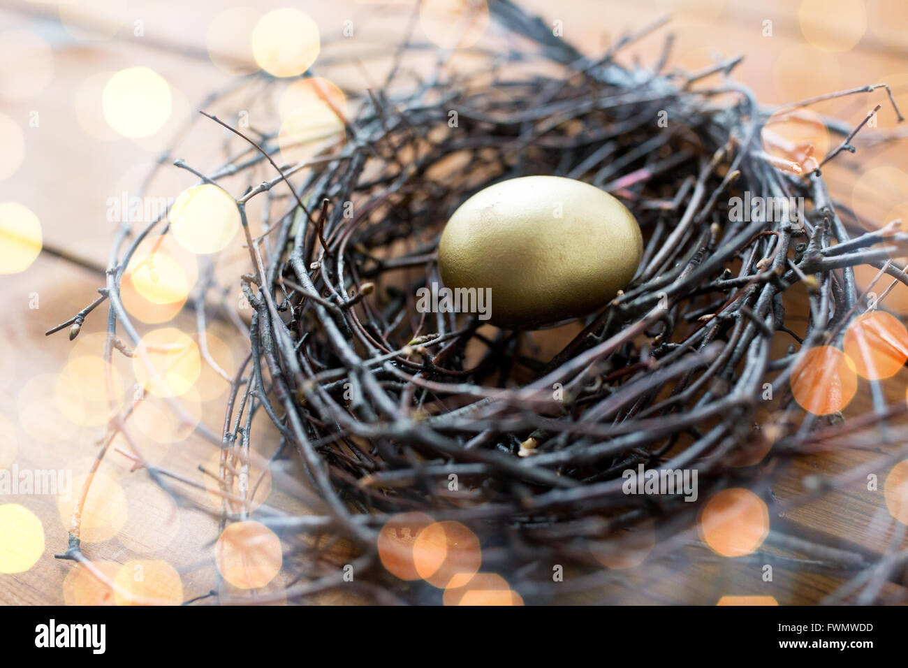 Close up golden uovo di pasqua nel nido in legno Foto Stock