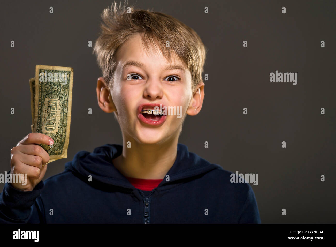 Ritratto in studio di ragazzo bianco con dente bretelle azienda uno le fatture del dollaro Foto Stock