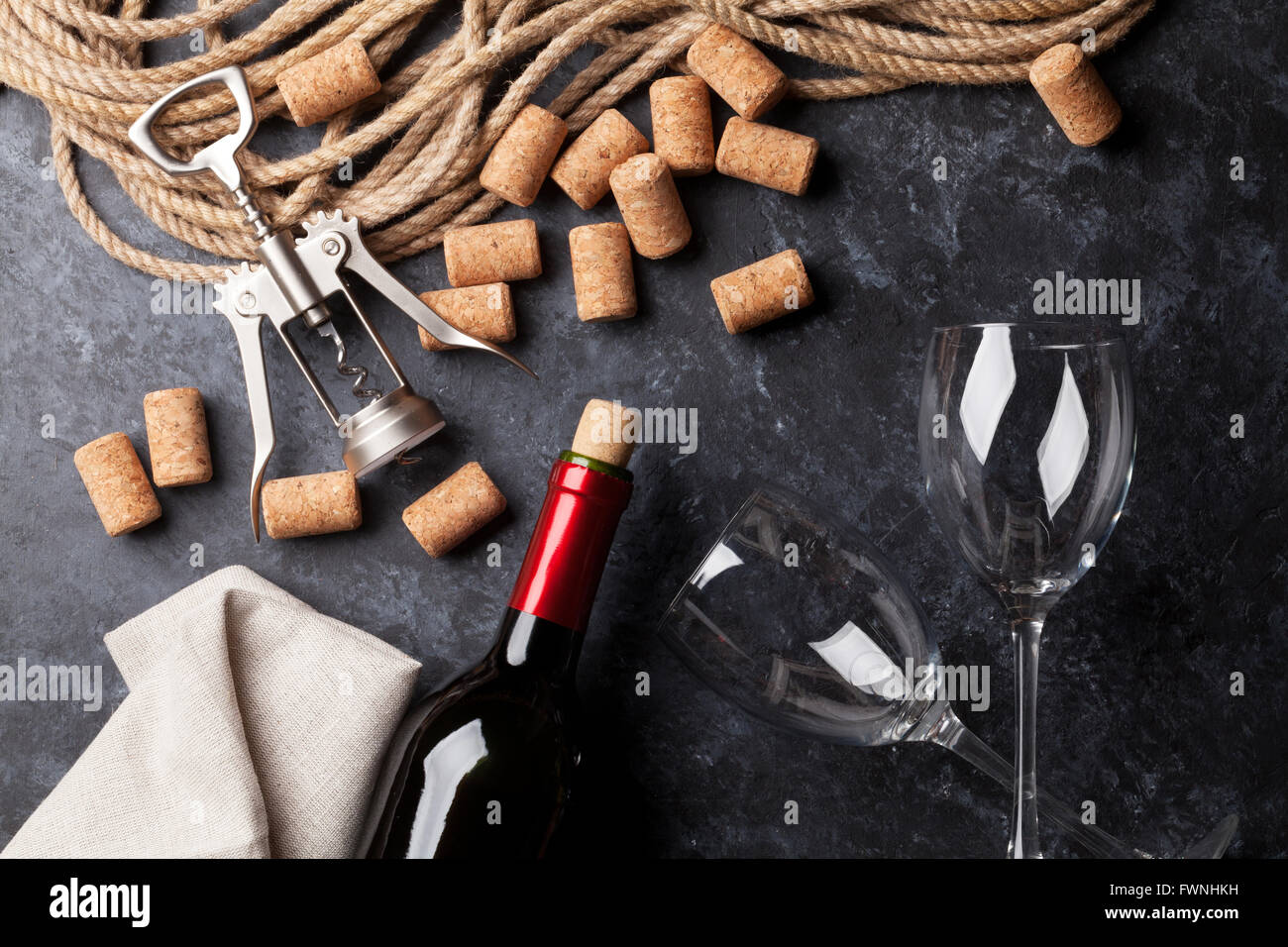 Vino, bicchieri e cavatappi su sfondo di pietra. Vista superiore Foto Stock