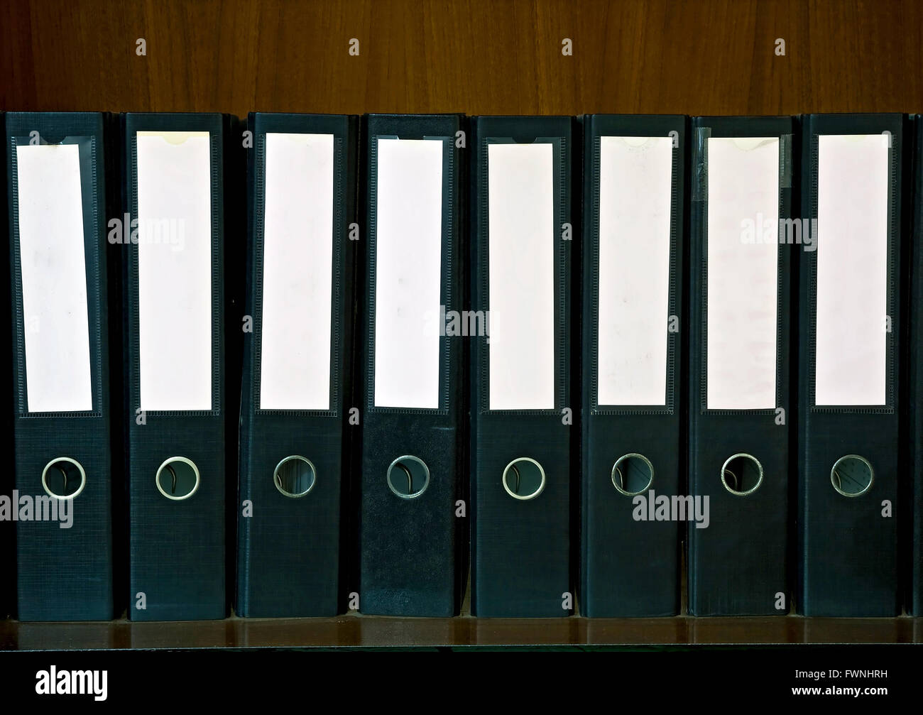 Ripiano in legno con le cartelle dei documenti e l'etichetta vuota Foto Stock