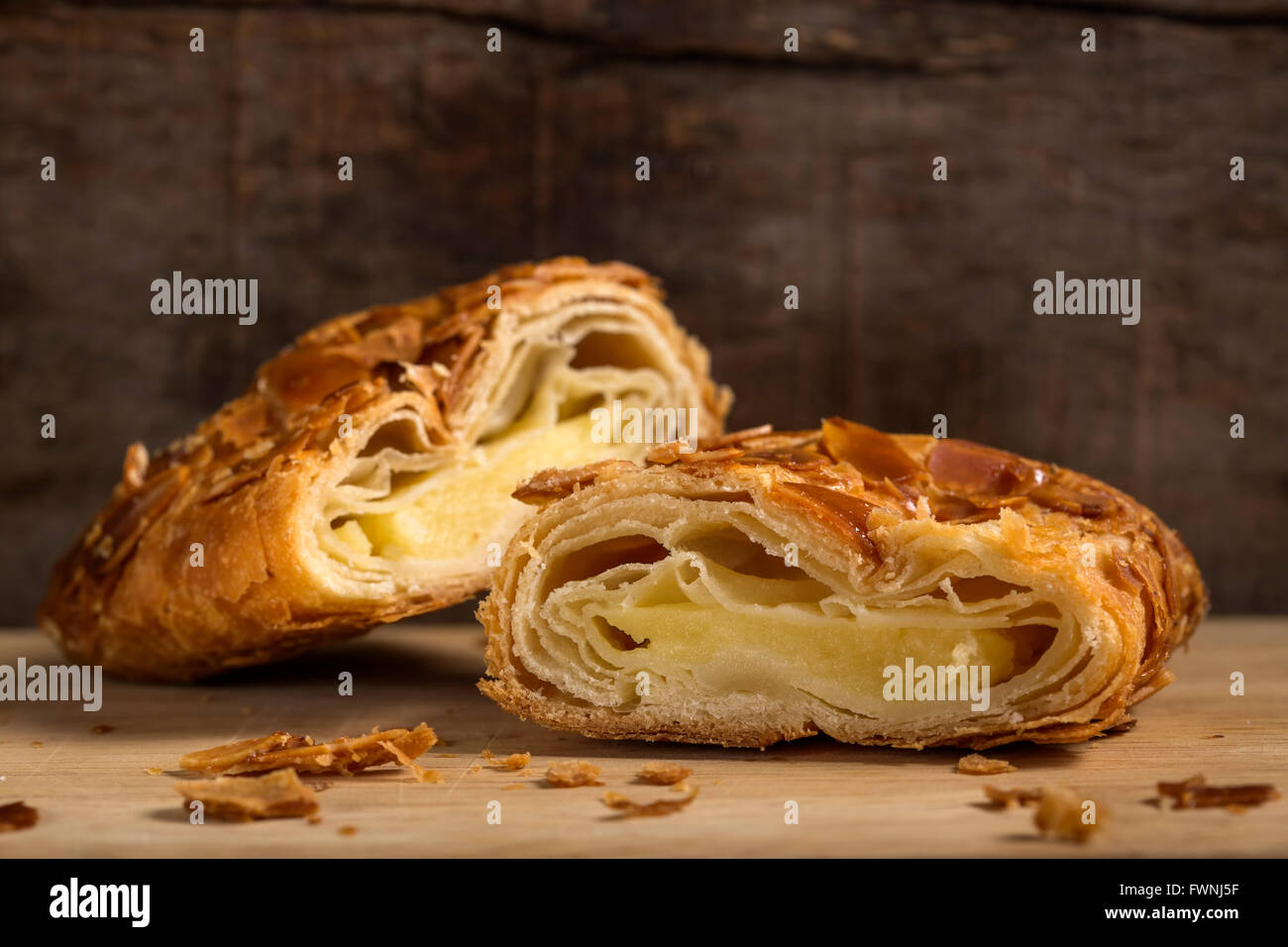 La sezione di uno strudel con mandorle e gelato alla vaniglia oltre rustico sfondo di legno Foto Stock