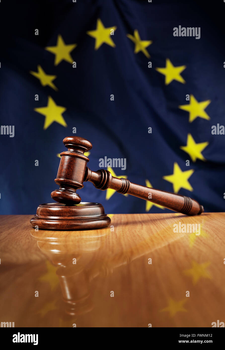 In legno di mogano martello sul lucido tavolo in legno. Bandiera dell'Unione europea, Unione europea, in background. Foto Stock