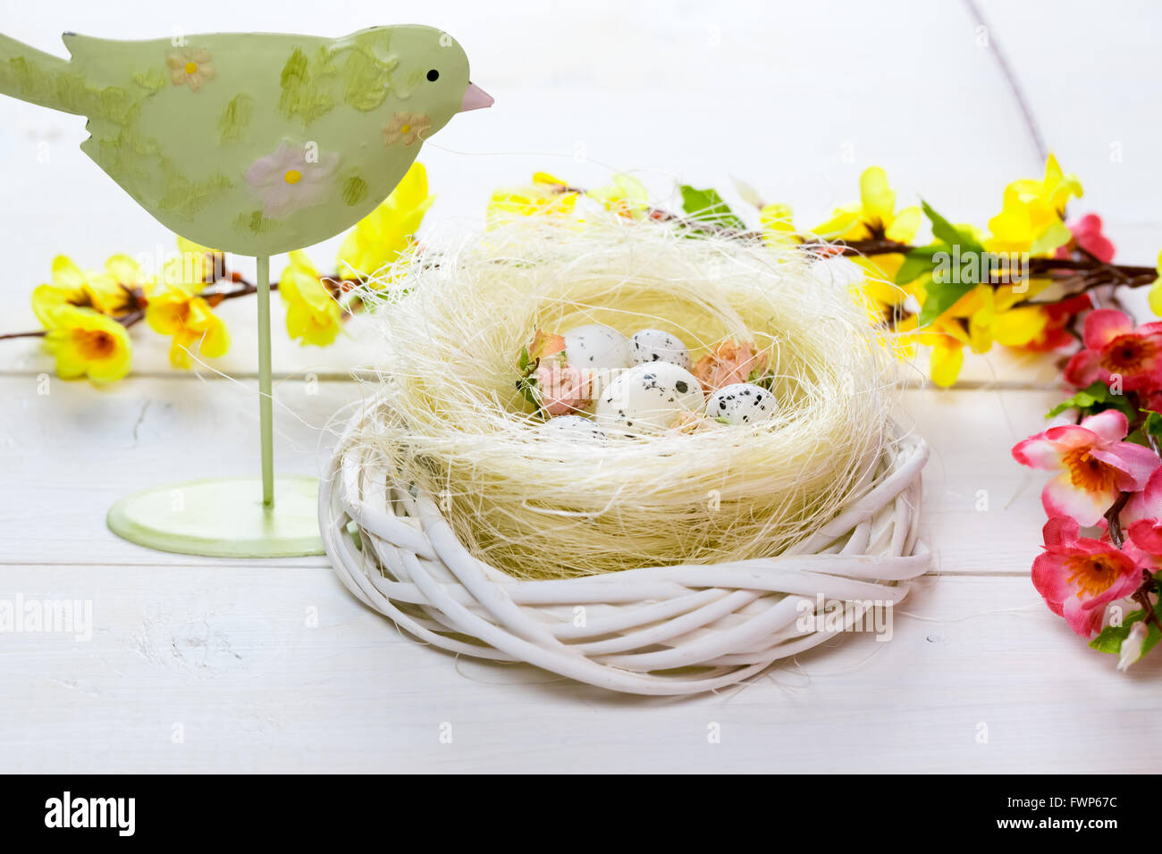 Bellissimo sfondo di pasqua con bird e nido con uova sul dipinto di bianco di tavole Foto Stock