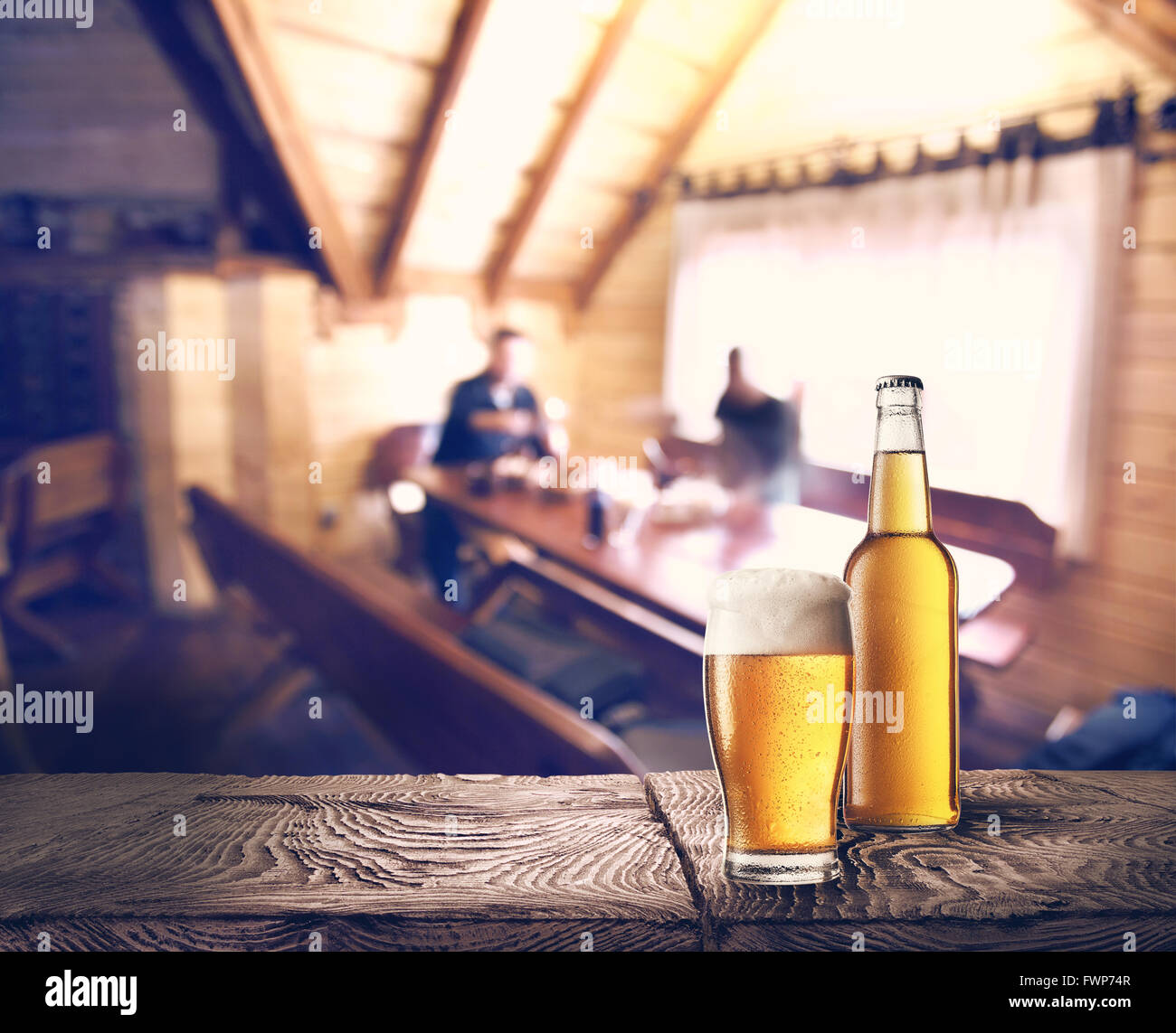 Bottiglia e bicchiere di birra sul tavolo contro lo sfondo di cafe Foto Stock