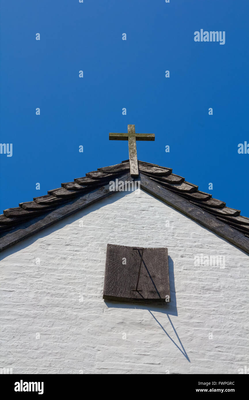 Piccola croce religiosa fissata alla sommità di una casa gable Foto Stock