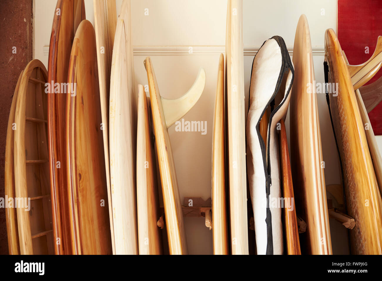 Fila di schede artigianali su misura in officina di tavole da surf Foto Stock