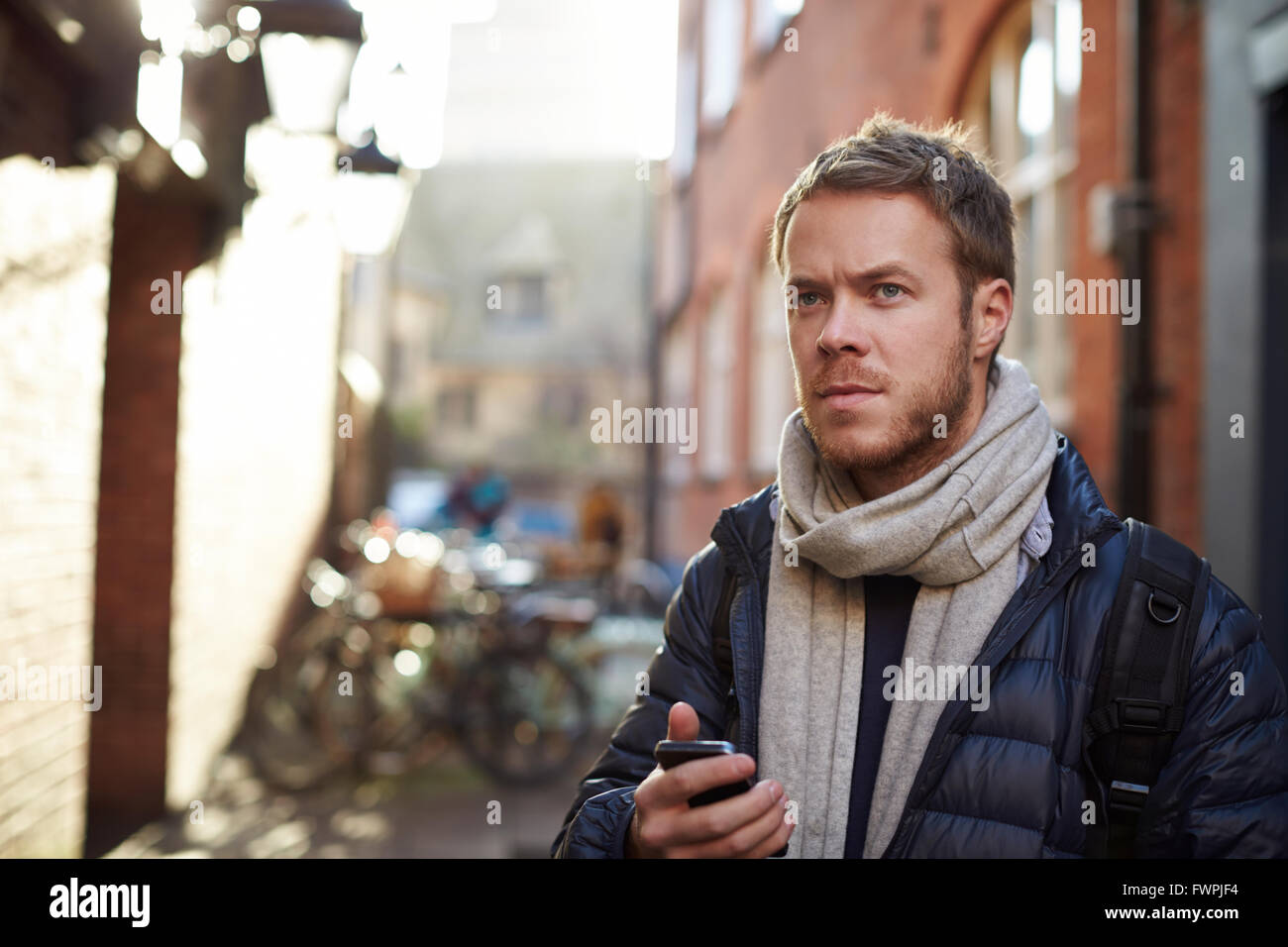 L'uomo utilizza il cellulare per navigare un percorso cittadino Foto Stock