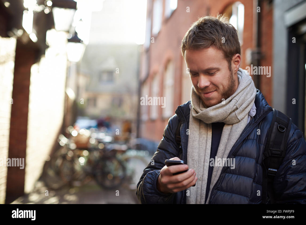 L'uomo utilizza il cellulare per navigare un percorso cittadino Foto Stock