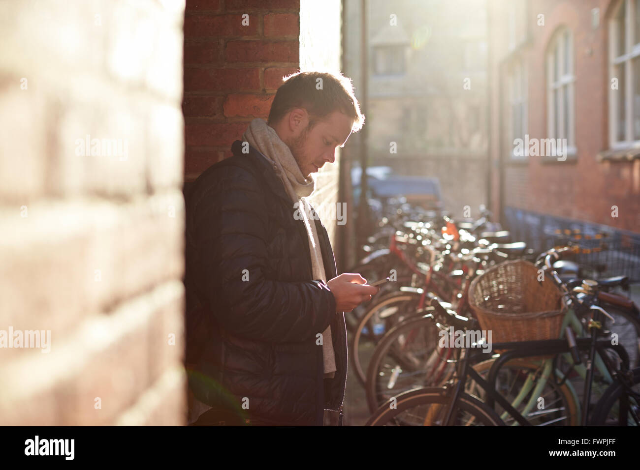 L'uomo utilizza il cellulare per navigare un percorso cittadino Foto Stock