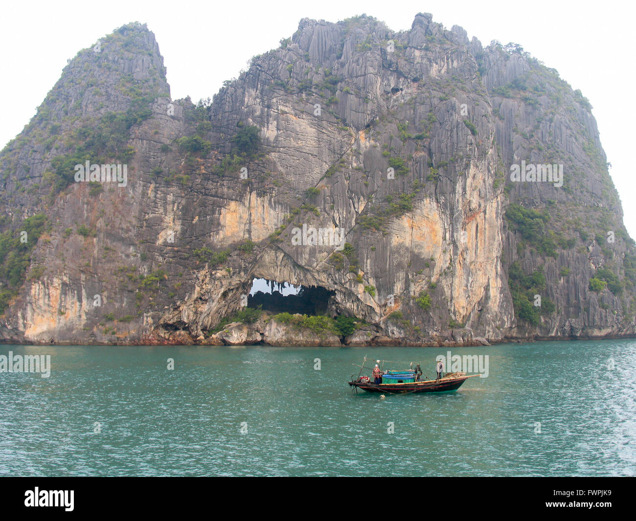 La tradizionale attività di pesca svolta da una imbarcazione in legno nella baia di Halong, Vietnam. Foto Stock