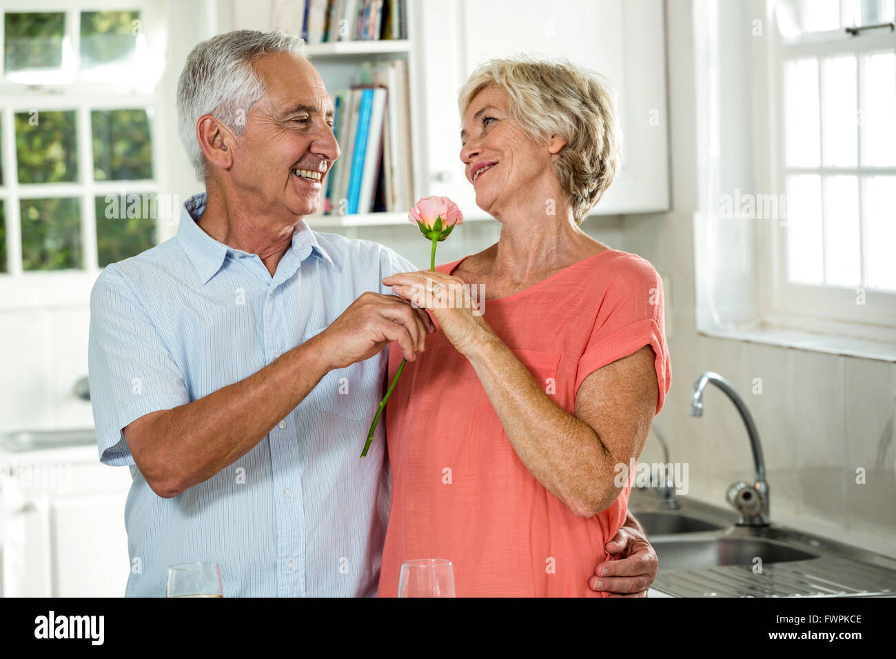 Sorridente uomo senior dando rose per donna Foto Stock