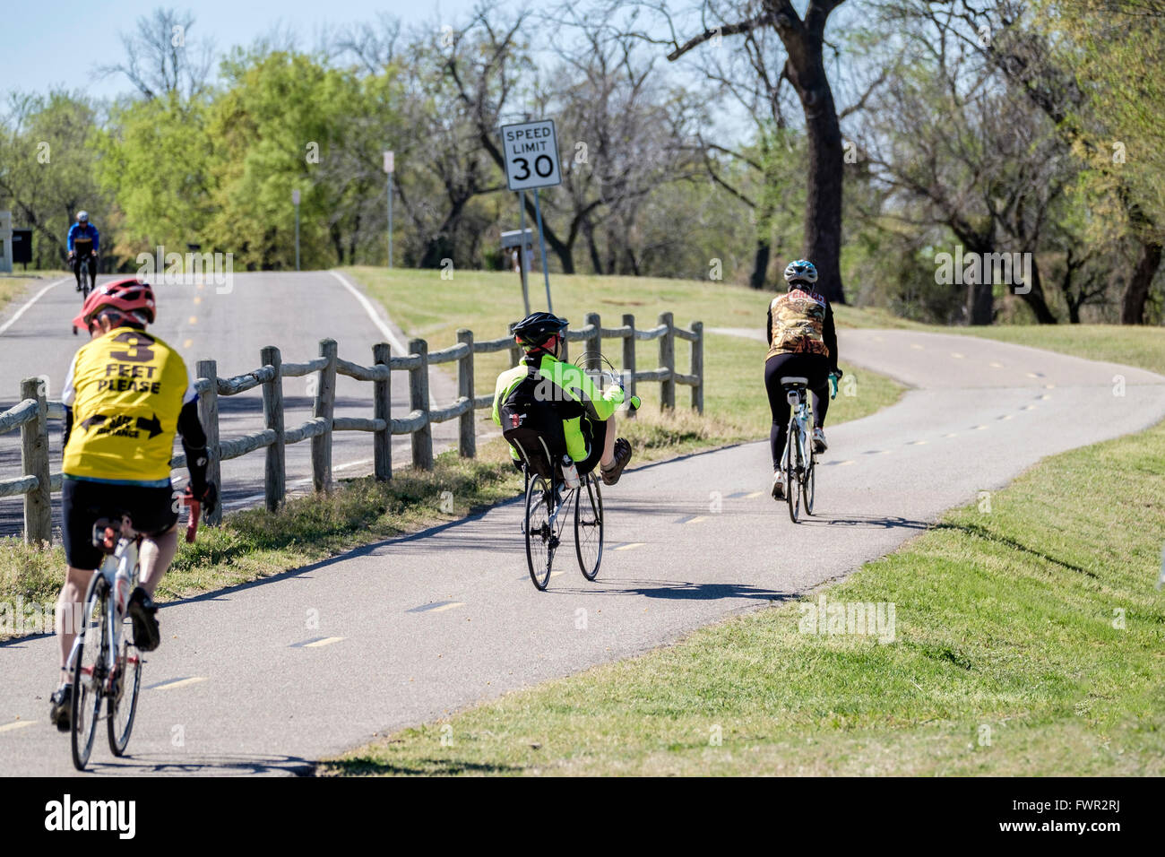 Due uomini e una donna in bicicletta su sentieri in Oklahoma City, Oklahoma, Stati Uniti d'America. Foto Stock