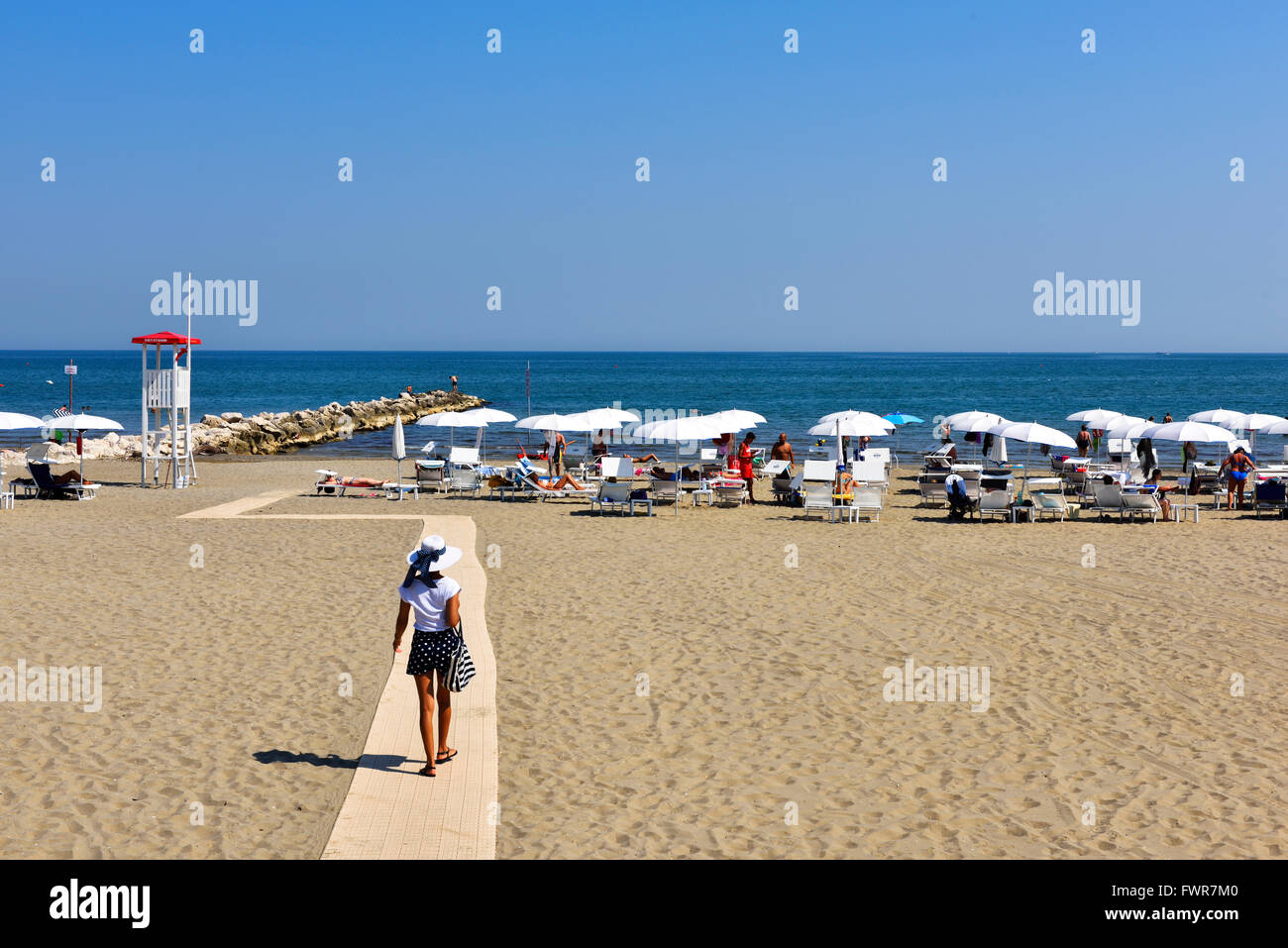 Donna di camminare sulla spiaggia, Lido di Venezia city beach, Venezia, Veneto, Italia Foto Stock