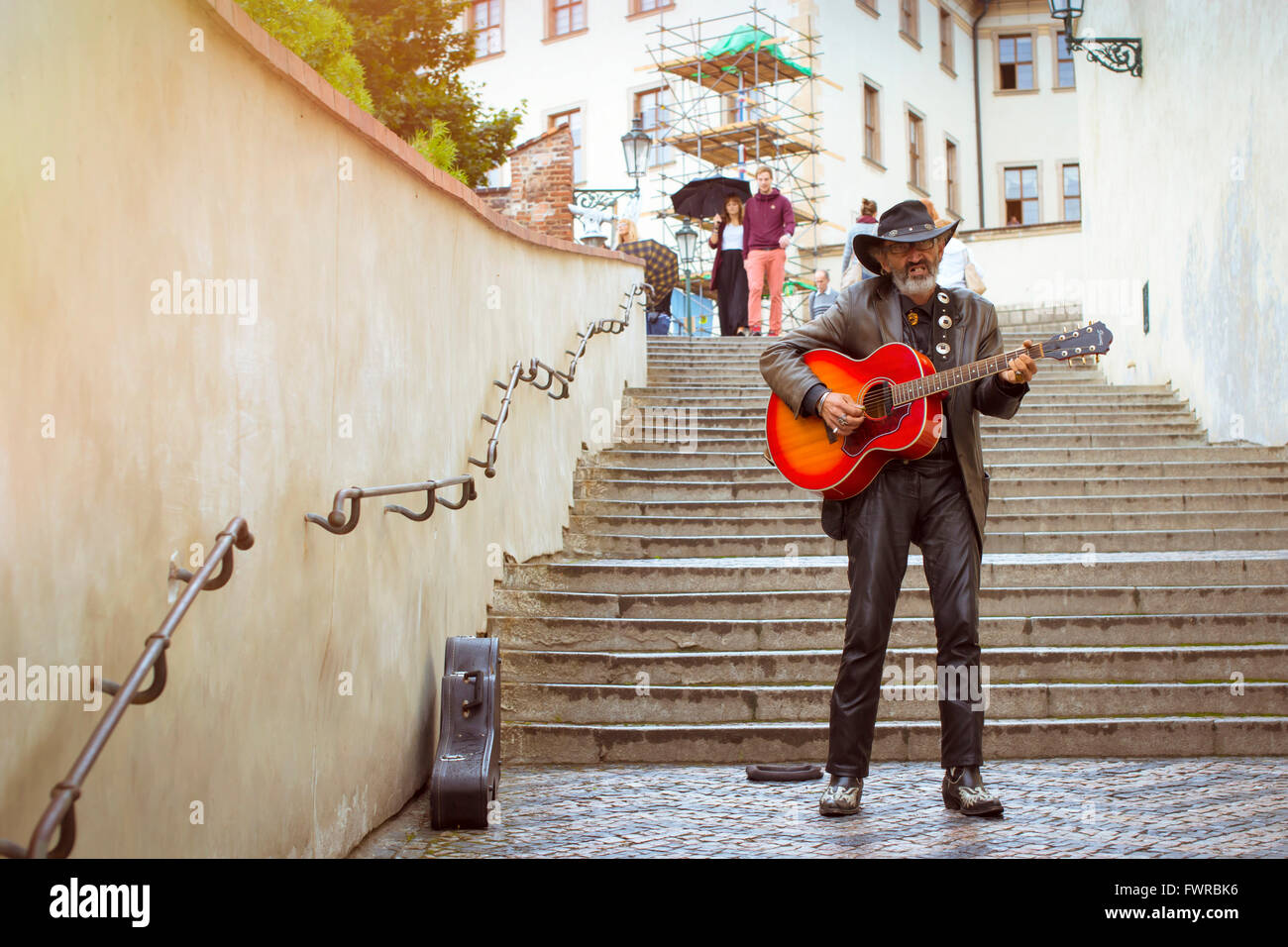 Praga, Repubblica Ceca - 25 agosto 2015: musicista di strada con un cappello e con una chitarra sulle scale di alta nel quartiere Mala Foto Stock