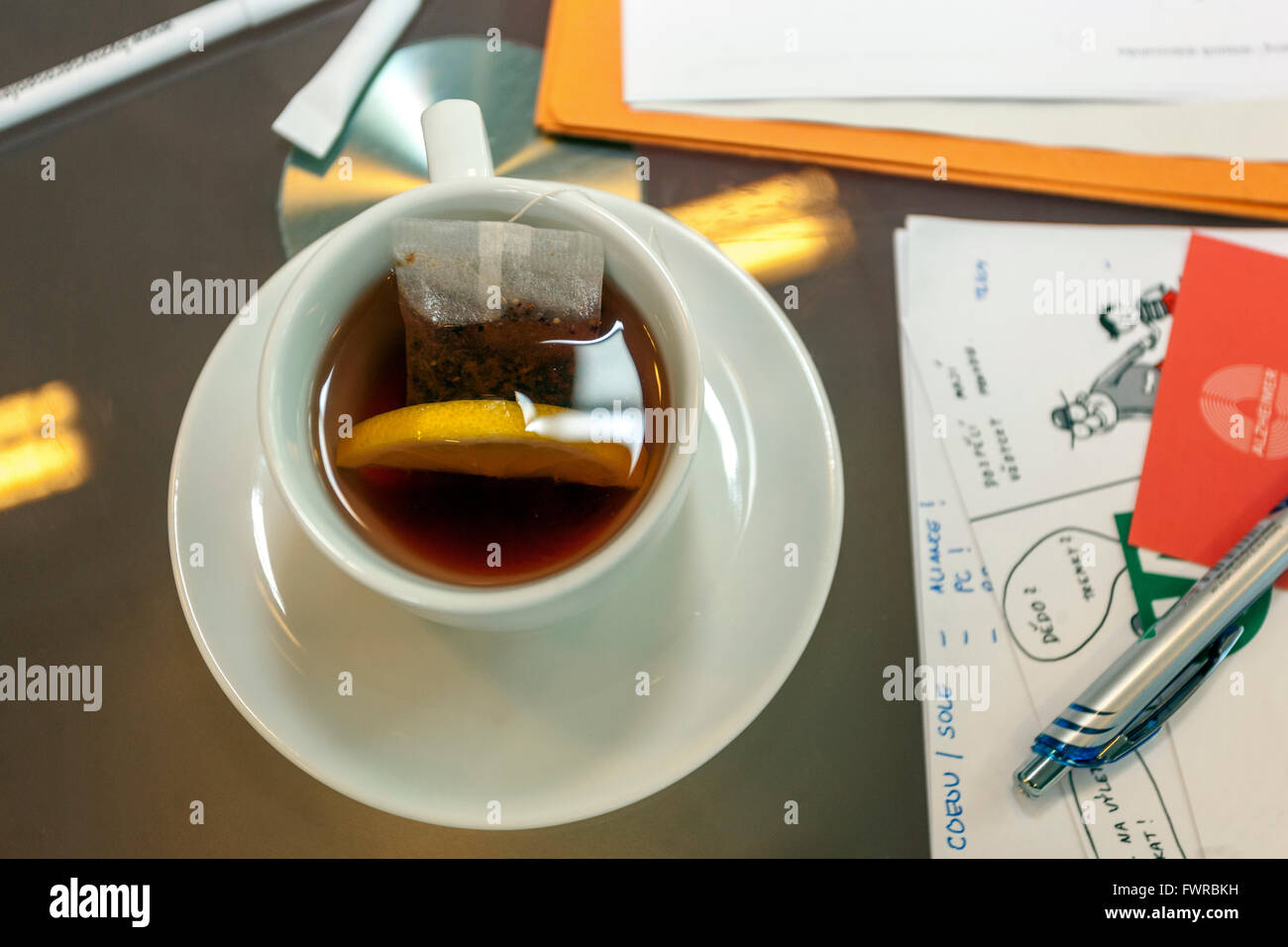 Tazza di tè sul tavolo da lavoro tra i documenti Foto Stock