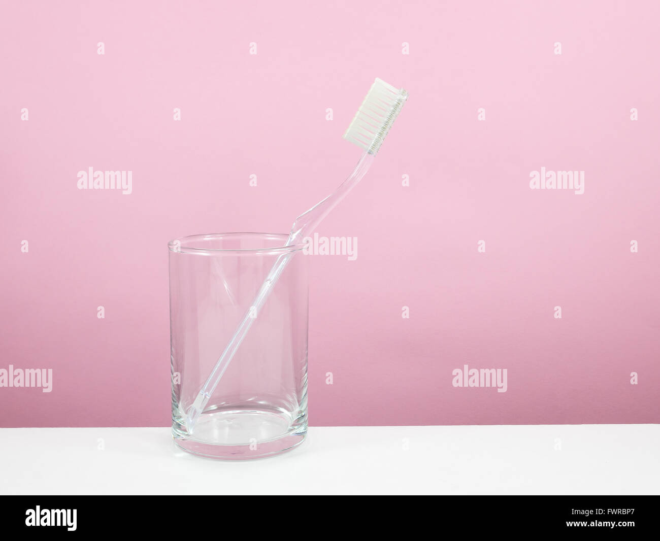 Il chiaro spazzolino da denti con un bicchiere piccolo per spazzolare i denti. Foto Stock
