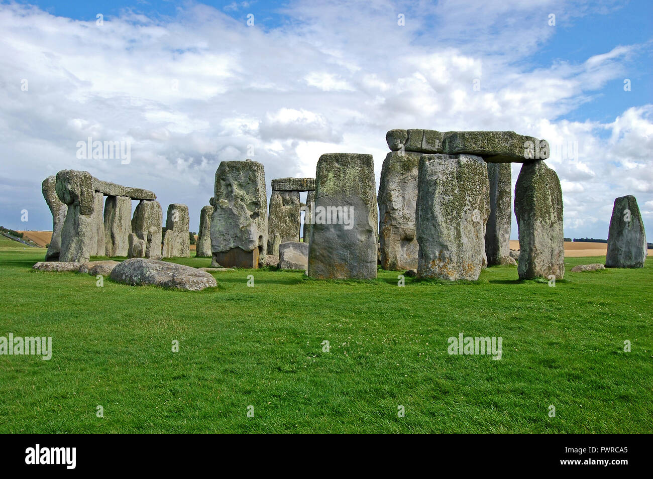 Il cerchio di pietre di Stonehenge, appare magnifico, sotto un cielo blu completo con soffici nuvole bianche, England, Regno Unito Foto Stock