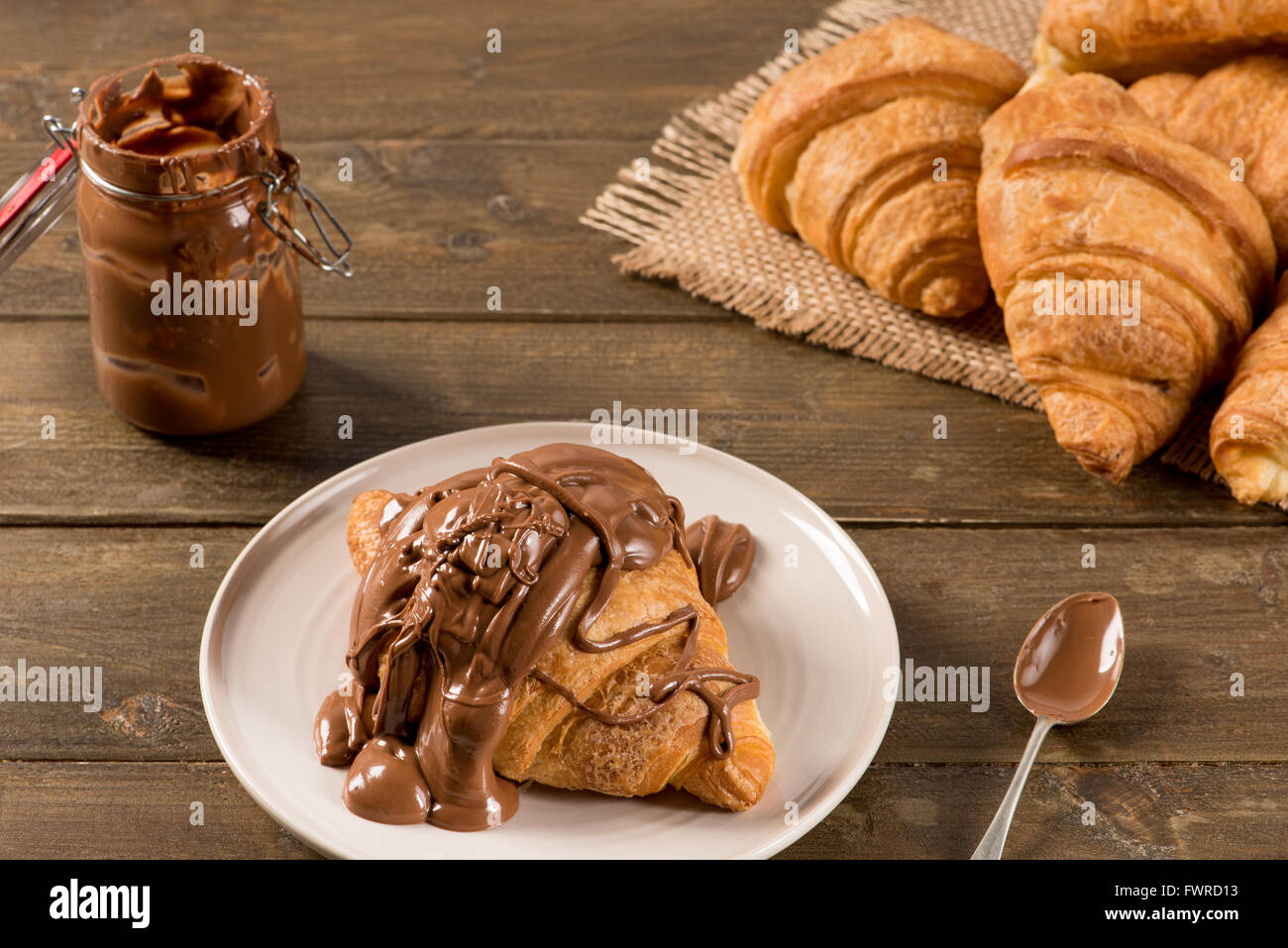 La prima colazione con croissant al cioccolato su un sfondo rustico Foto Stock