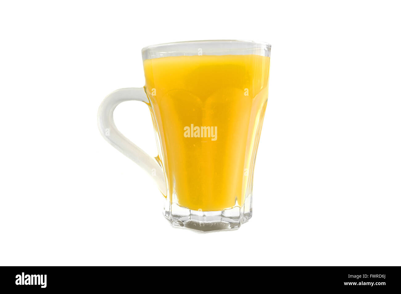 Un bicchiere di vetro con colore arancio il liquido in esso fotografati contro uno sfondo bianco. Foto Stock