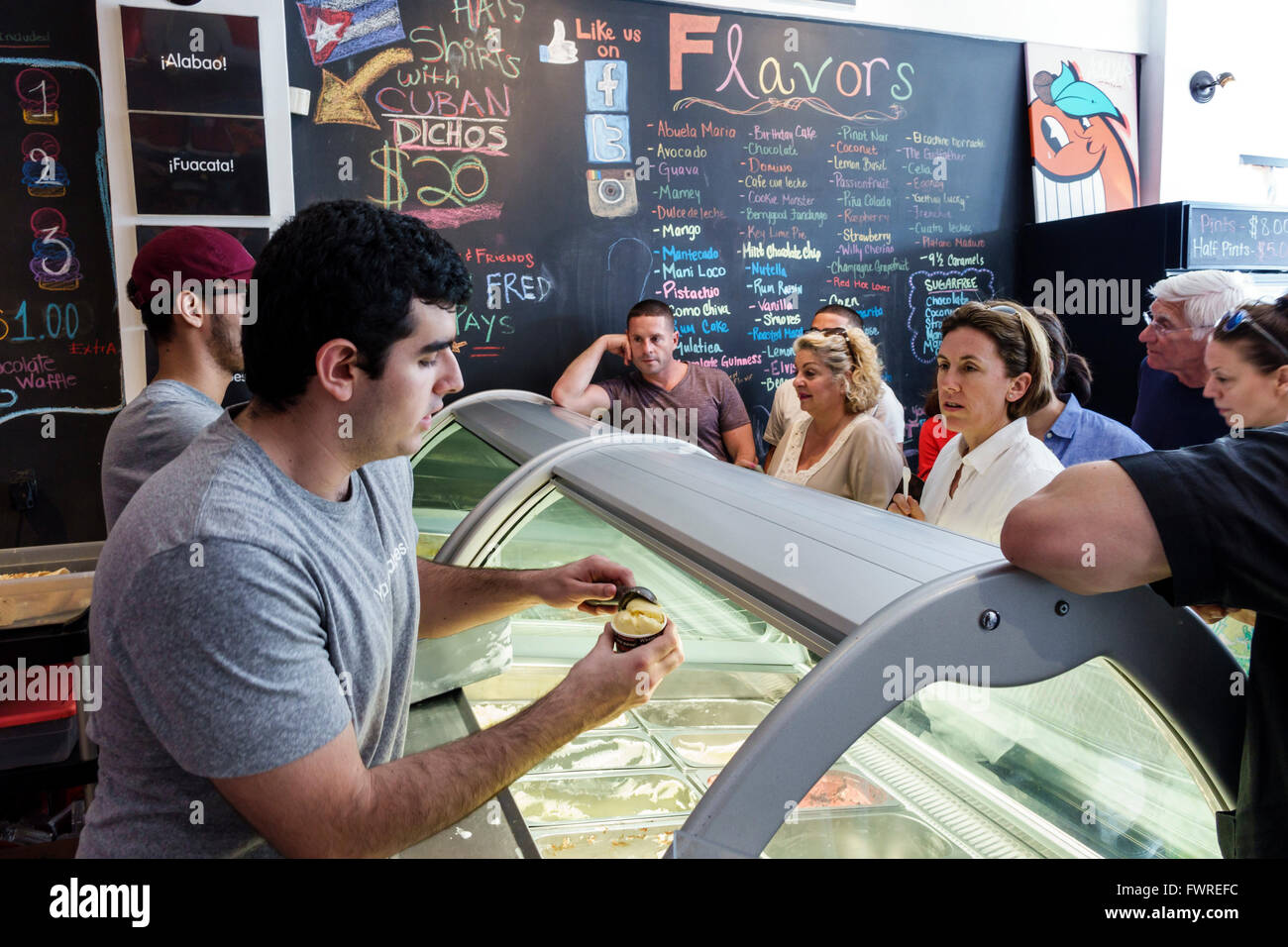 Miami Florida,Little Havana,Calle Ocho,adulto ispanico,adulti,uomo uomo maschio,Azucar Ice Cream Company,interno,banco,clienti,linea,coda,servin Foto Stock